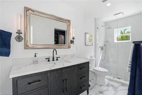 a bathroom with a double vanity sink toilet and a mirror