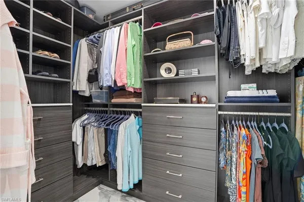 a view of walk in closet with clothes and shoes