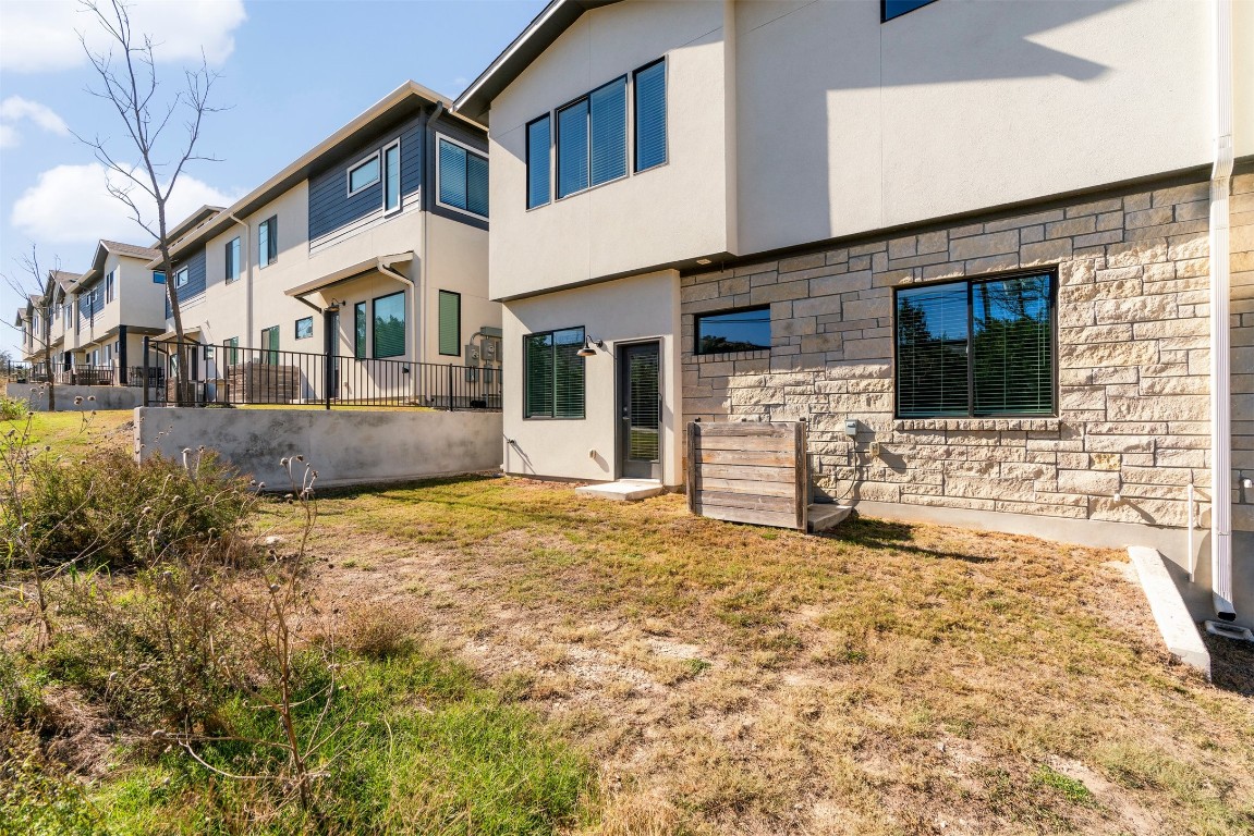 2050 Lohmans Spur Road, Unit 2203 Lakeway, TX 78734 - Photo 29 of 34 Just beyond the home, the grassy yard space offers a rare bonus for townhome living, providing a convenient outdoor area that’s ideal for pets and easy everyday use