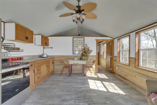 a large kitchen with kitchen island granite countertop a large window cabinets and stainless steel appliances