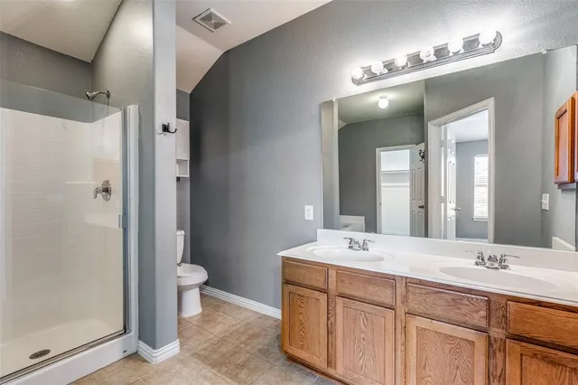 a bathroom with a double vanity sink mirror and toilet