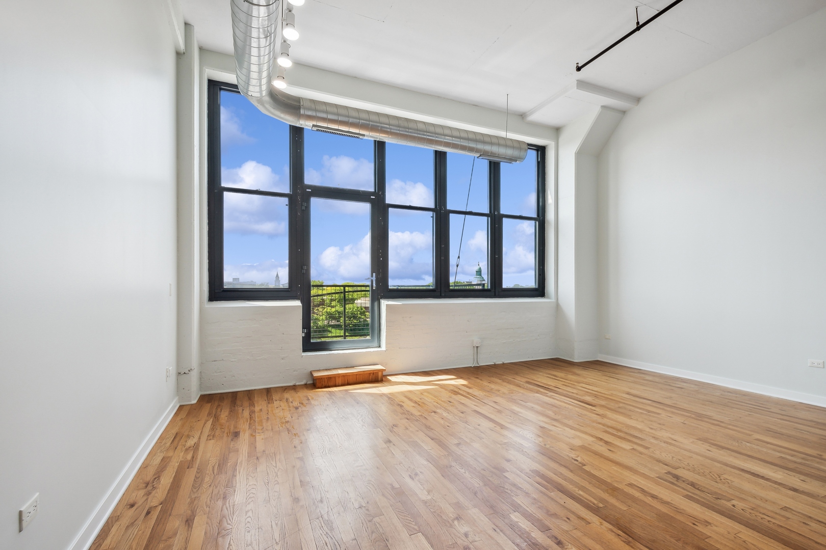 1224 West Van Buren Street, Unit 301 Chicago, IL 60607 - Photo 2 of 14 wooden floor in an empty room with a window