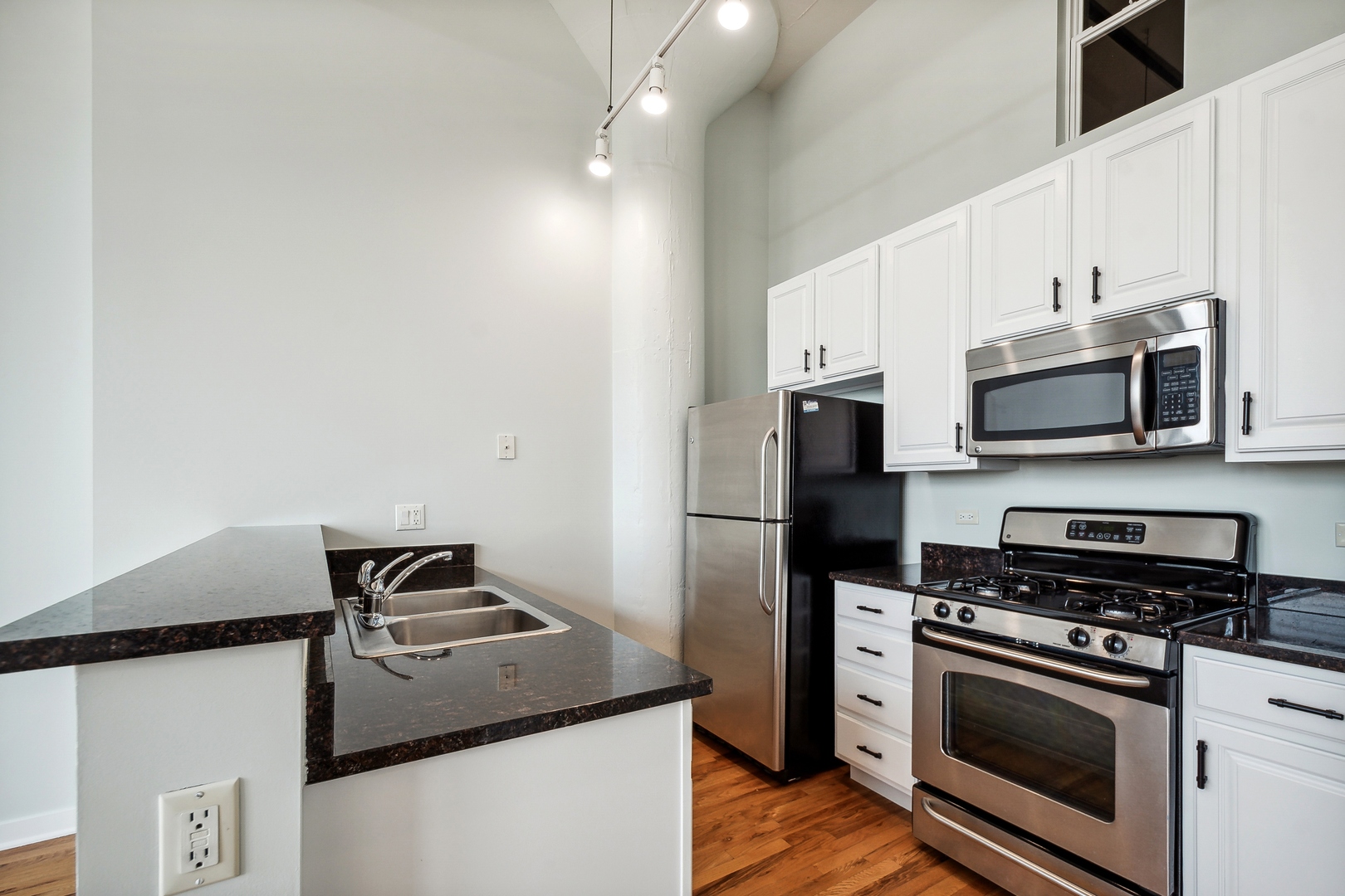 1224 West Van Buren Street, Unit 301 Chicago, IL 60607 - Photo 6 of 14 a kitchen with stainless steel appliances a stove microwave and a refrigerator