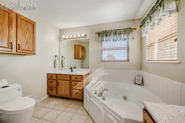 a spacious bathroom with a tub sink and mirror