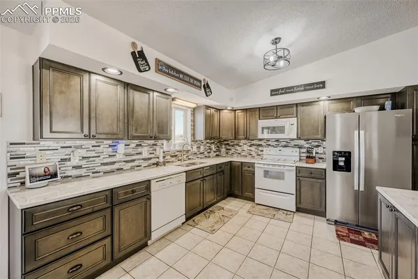 a kitchen with a stove a sink and a refrigerator
