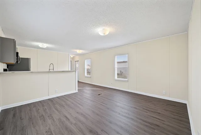 a view of a kitchen with wooden floor and electronic appliances
