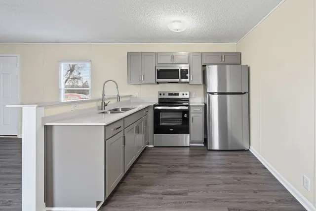 a kitchen with stainless steel appliances a refrigerator sink and stove