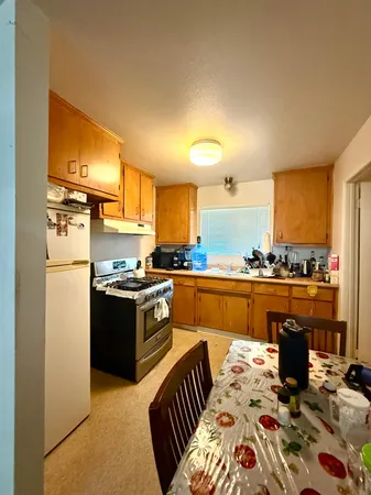 a kitchen with stainless steel appliances granite countertop a refrigerator a stove and a sink