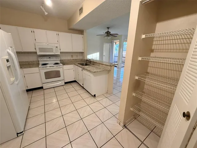 a kitchen with white cabinets and white appliances