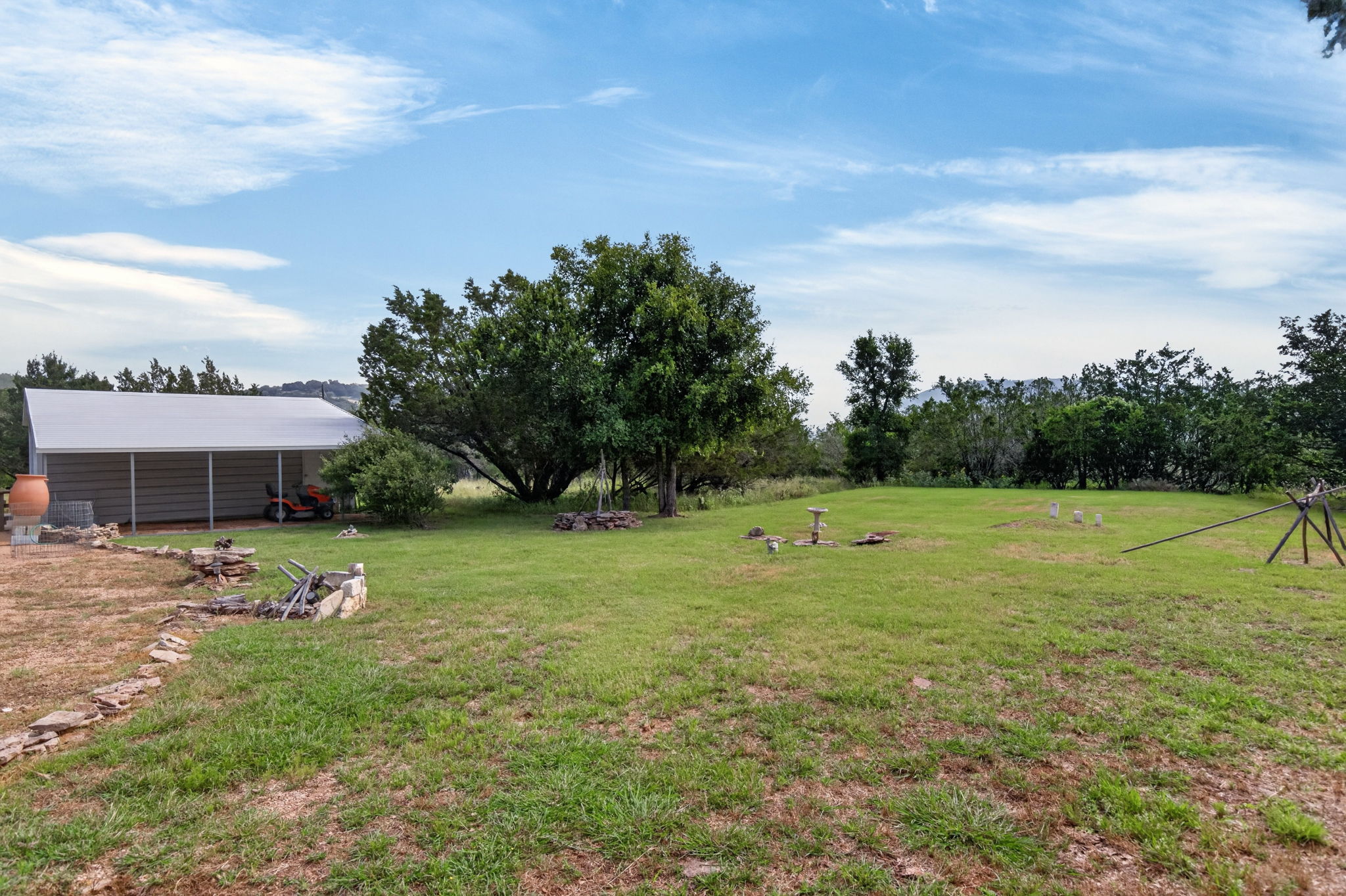 207 Deer Ridge Drive Burnet, TX 78611 - Photo 13 of 36 A spacious back yard with mature trees, and an open-sided outbuilding provide ample room for outdoor activities.