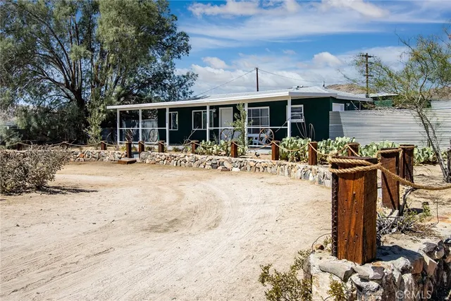 a row of palm trees in front of a house