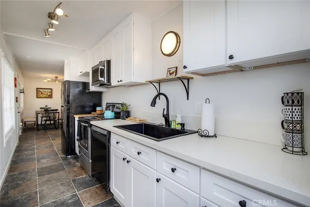 a kitchen with stainless steel appliances granite countertop a sink a stove and cabinets