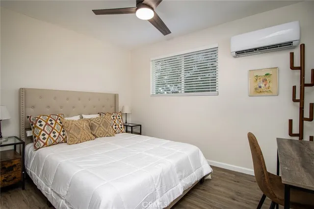 a bedroom with bed and wooden floor