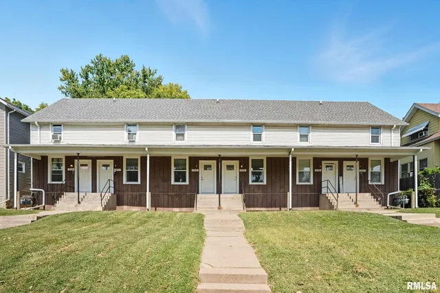 front view of a brick house with a yard