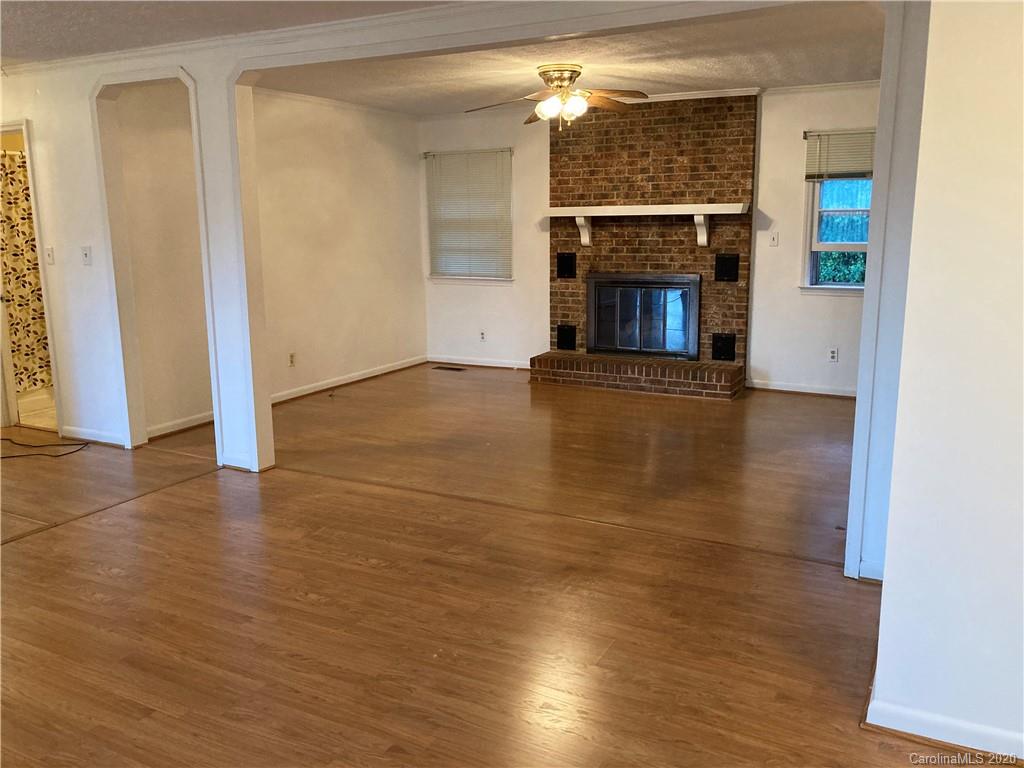 1851 Stoney Point Road Shelby, NC 28150 - Photo 5 of 26 an empty room with wooden floor fireplace and cabinet