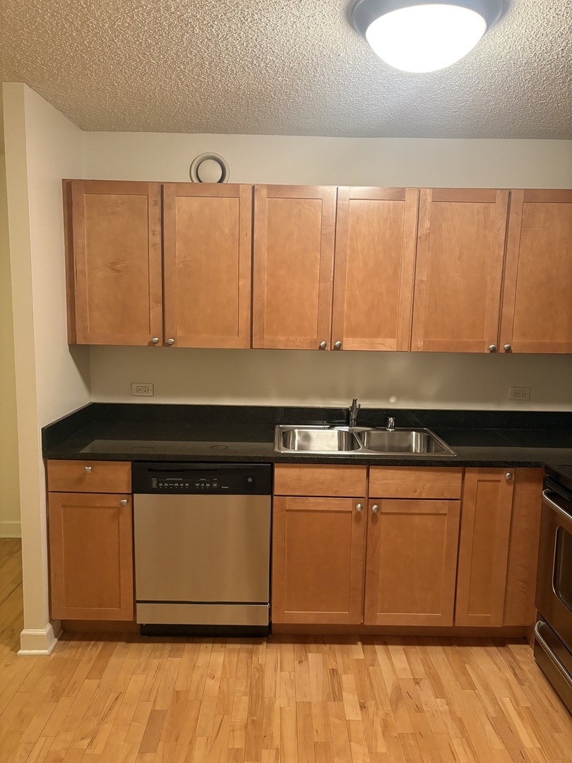 30 East Huron Street, Unit 3601 Chicago, IL 60611 - Photo 6 of 15 a kitchen with stainless steel appliances granite countertop a stove a sink and a microwave