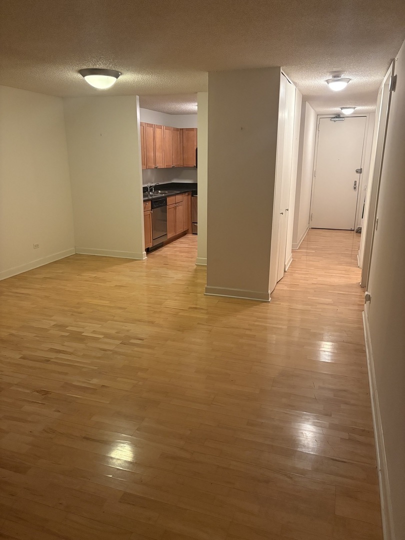 30 East Huron Street, Unit 3601 Chicago, IL 60611 - Photo 10 of 15 a view of kitchen and empty room with wooden floor