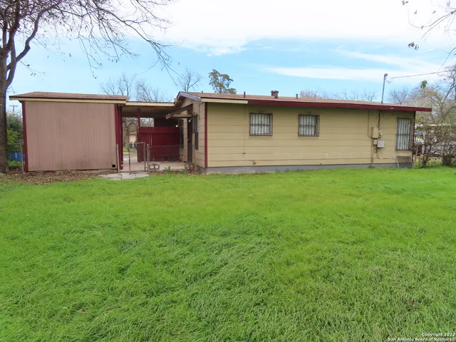 a view of a backyard with table and chairs and a barbeque