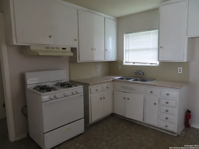 a kitchen with granite countertop white cabinets and white appliances