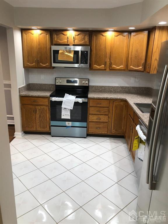a kitchen with stainless steel appliances kitchen island granite countertop a sink and a stove