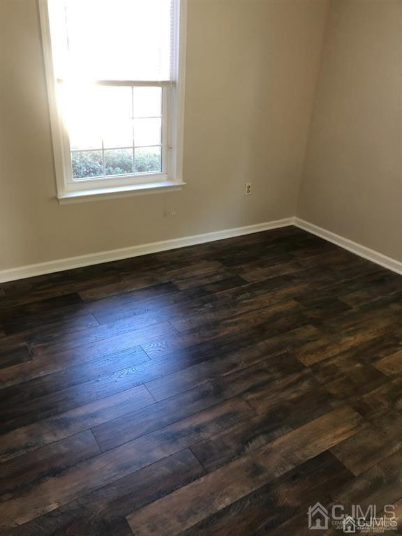 126 Concordia Circle, Unit G Monroe Township, NJ 08831 - Photo 8 of 14 an empty room with wooden floor and windows