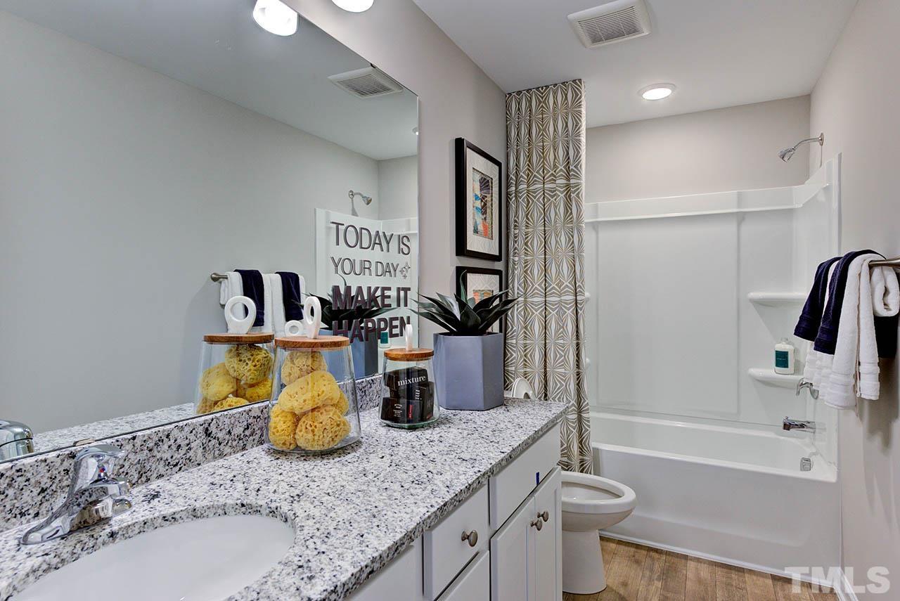 6932 Leesville Road, Unit 7 Raleigh, NC 27613 - Photo 25 of 44 a bathroom with a granite countertop sink a toilet and bathtub