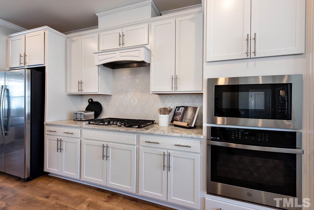 6932 Leesville Road, Unit 7 Raleigh, NC 27613 - Photo 32 of 44 a kitchen with granite countertop white cabinets and stainless steel appliances