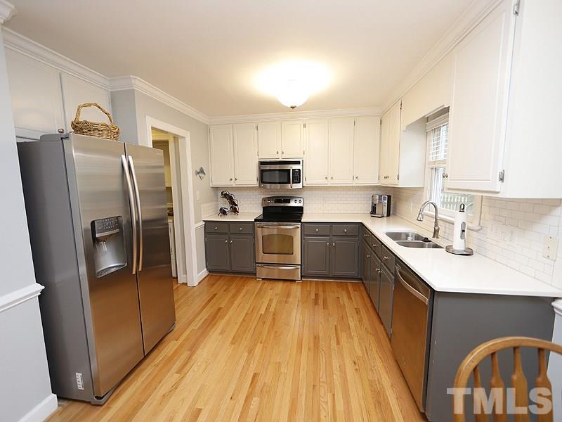 9112 Cub Trail Raleigh, NC 27615 - Photo 5 of 13 a kitchen with a sink a counter top space stainless steel appliances and a window