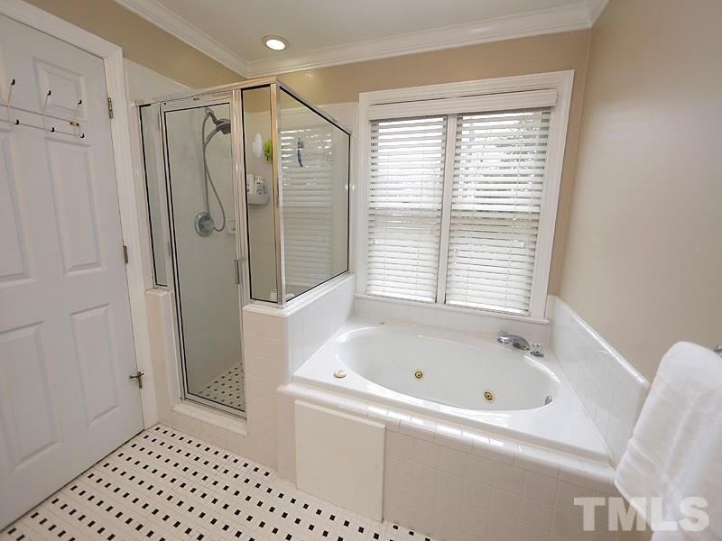9112 Cub Trail Raleigh, NC 27615 - Photo 8 of 13 a bathroom with a bathtub a shower and a window