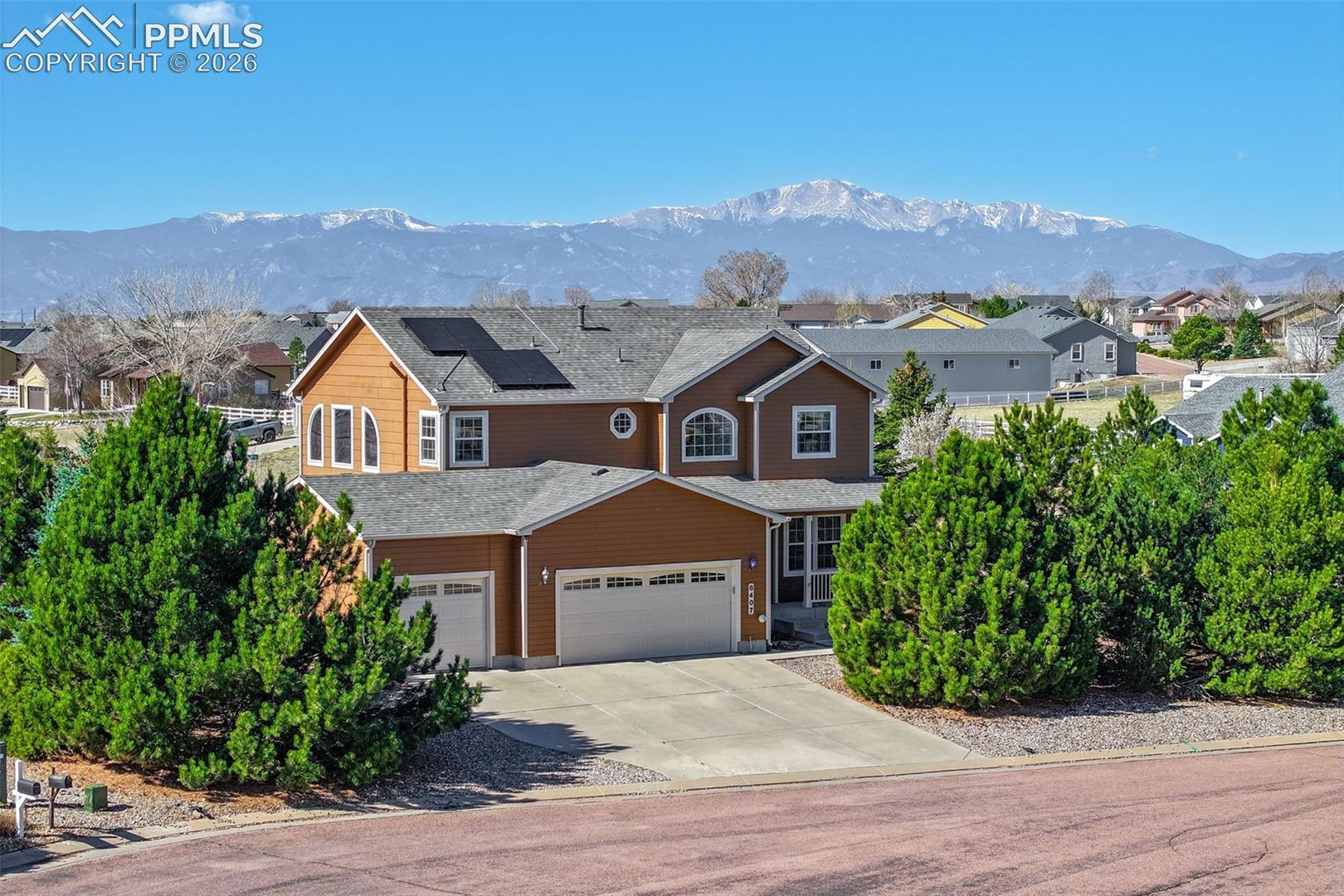 8407 Weiscamp Road Peyton, CO 80831 - Photo 1 of 49 Traditional Home featuring roof mounted solar panels, driveway, a mountain view, an attached garage, and a residential view