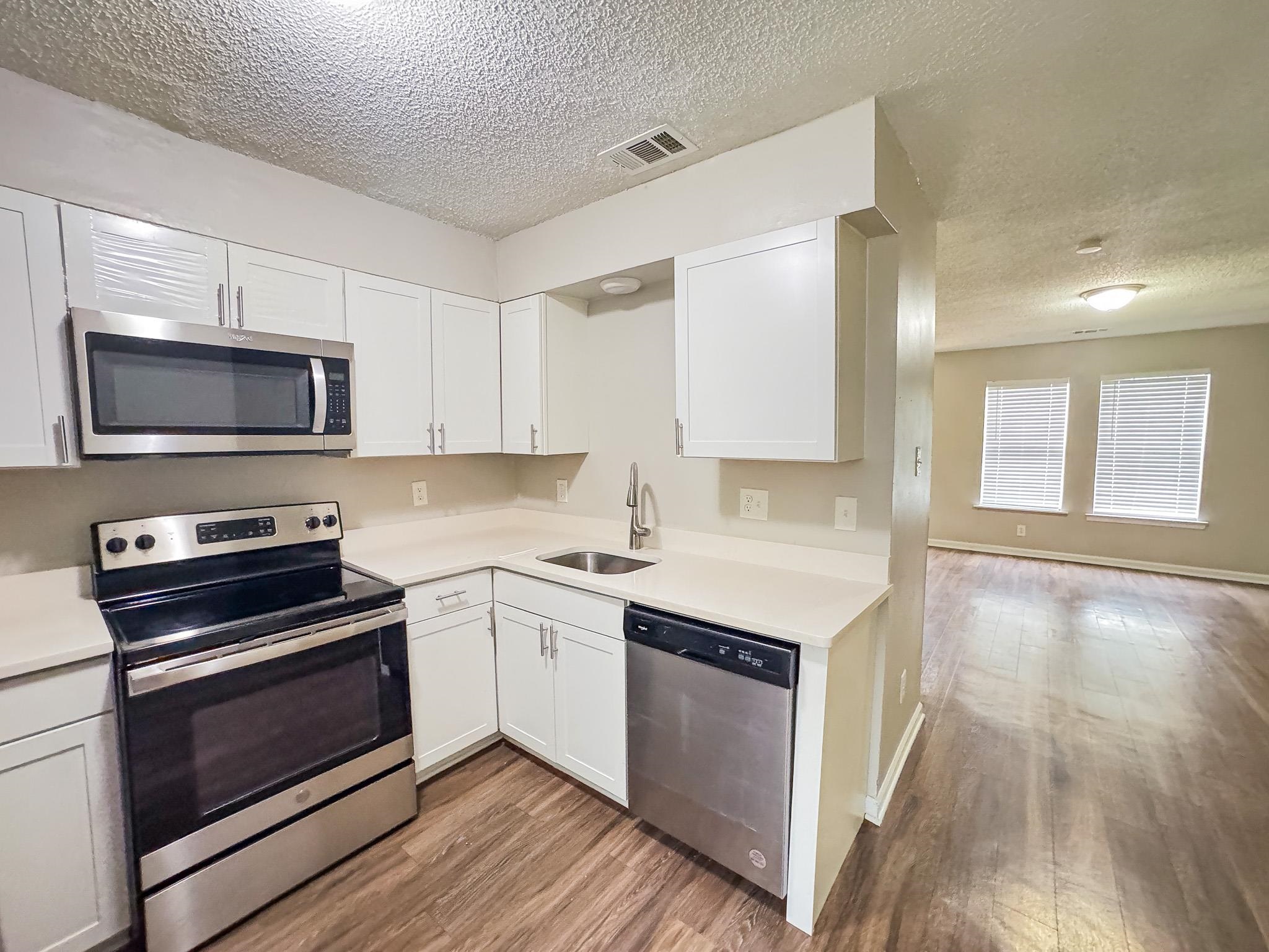 3592 Christine Road Memphis, TN 38118 - Photo 5 of 13 U-shaped kitchen featuring white cabinetry, stainless steel appliances, and a stainless steel sink with a gooseneck faucet