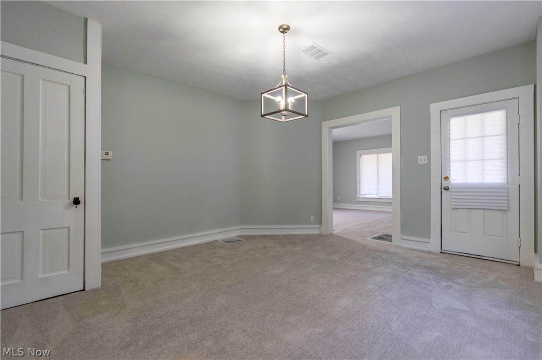 635 Mill Road Ravenna, OH 44266 - Photo 8 of 37 Carpeted spare room featuring an inviting chandelier