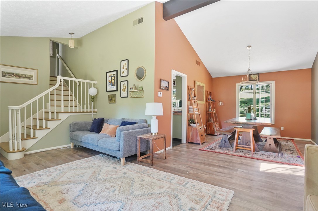 649 South Medina Line Road Akron, OH 44321 - Photo 9 of 50 Living area featuring light wood finished floors, stairway, high vaulted ceiling, and beamed ceiling