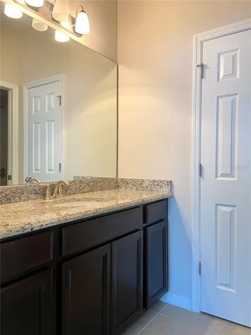 a bathroom with a granite countertop sink and a mirror