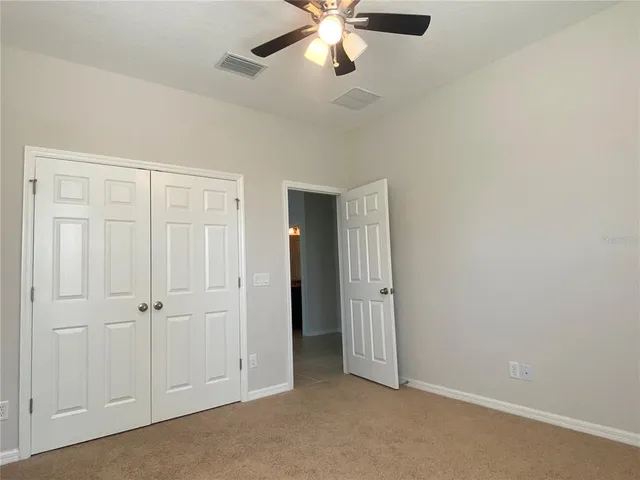 an empty room with chandelier fan