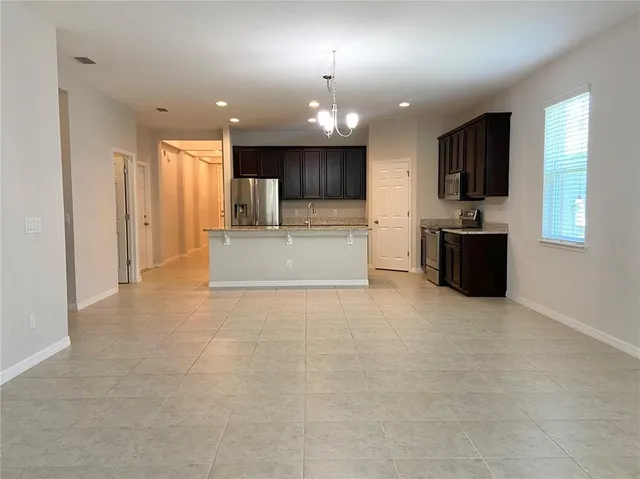 a large kitchen with a large counter top stainless steel appliances and cabinets