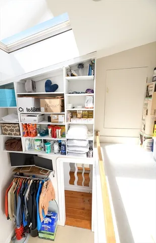a view of walk in closet with clothes and shoes