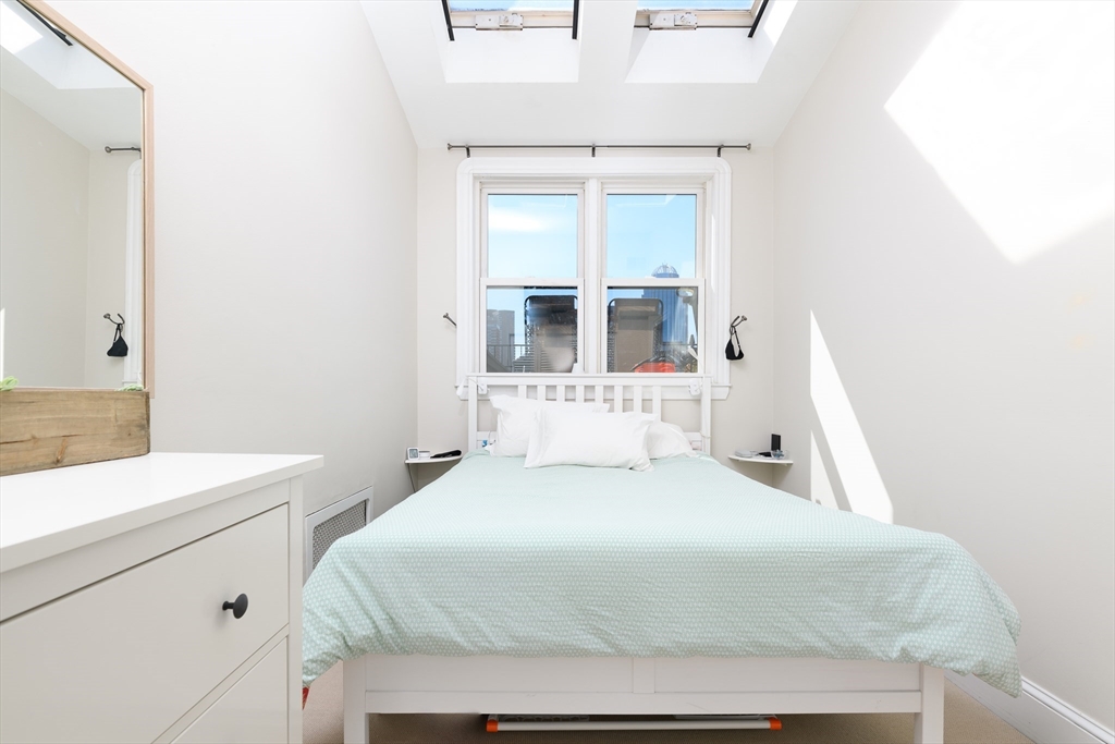 261 Marlborough Street, Unit 11 Boston, MA 02116 - Photo 10 of 17 a bedroom with a bed and a mirror