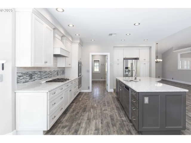 a kitchen with granite countertop a sink stove and refrigerator