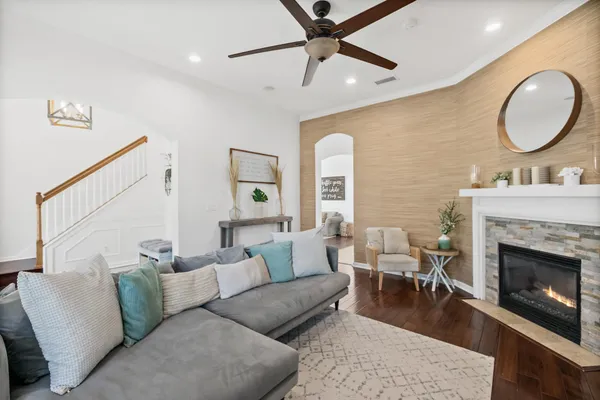 a living room with furniture and a dining table with wooden floor