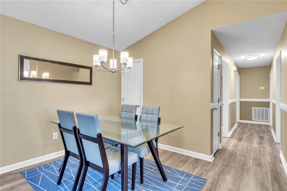 706 Pelham Square Way Greer, SC 29650 - Photo 8 of 20 This dining area features an elegant chandelier and warm wood flooring, perfect for gatherings.