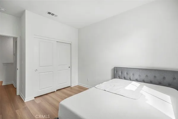 a bedroom with a bed and wooden floor