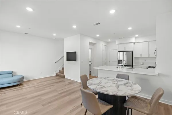 a kitchen with kitchen island white cabinets and stainless steel appliances