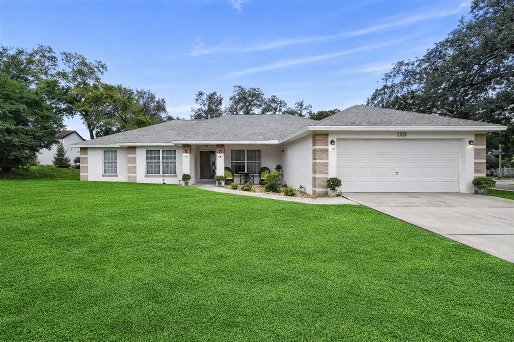 a view of a yard in front of a house with a large tree