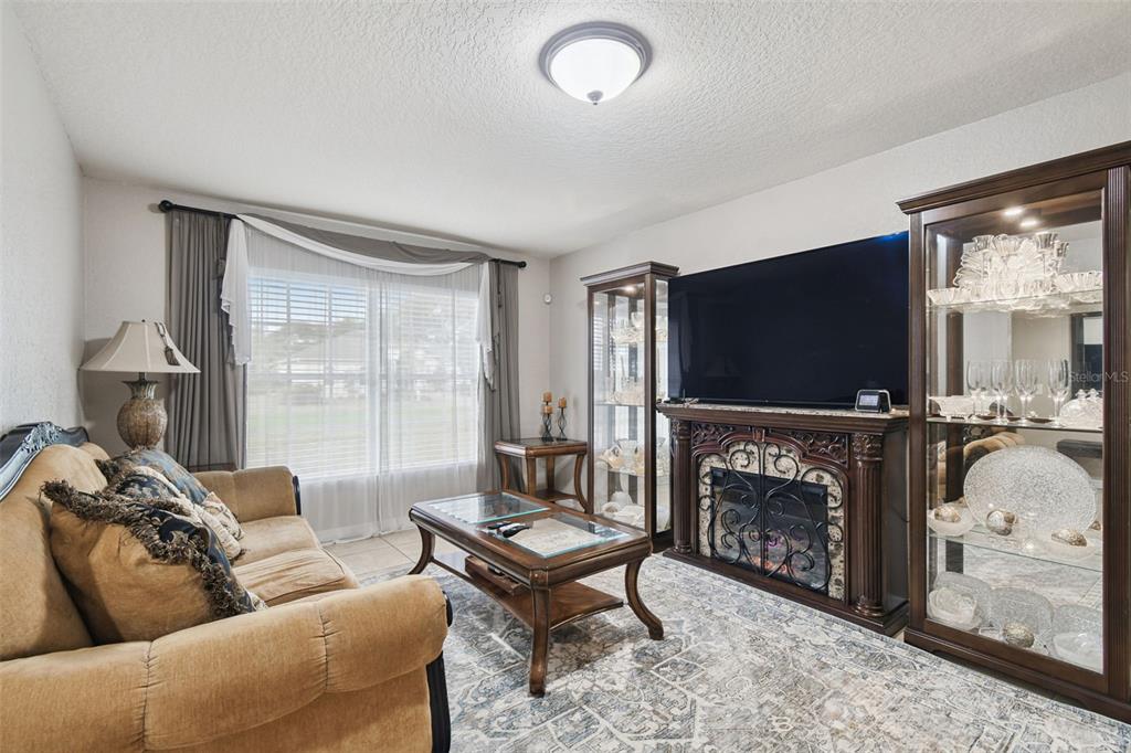 270 Planter Road Spring Hill, FL 34606 - Photo 13 of 33 a living room with furniture a flat screen tv and a fireplace