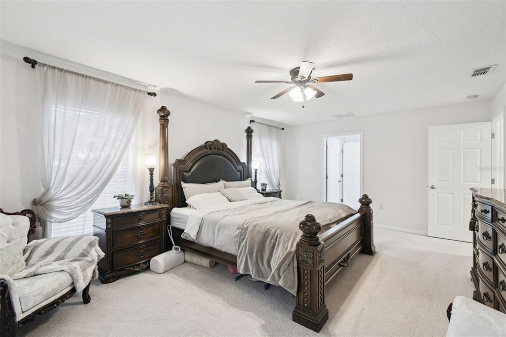 270 Planter Road Spring Hill, FL 34606 - Photo 16 of 33 a spacious bedroom with a bed and a chandelier