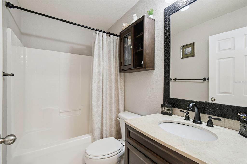 270 Planter Road Spring Hill, FL 34606 - Photo 20 of 33 a bathroom with a granite countertop bathtub sink vanity mirror and toilet