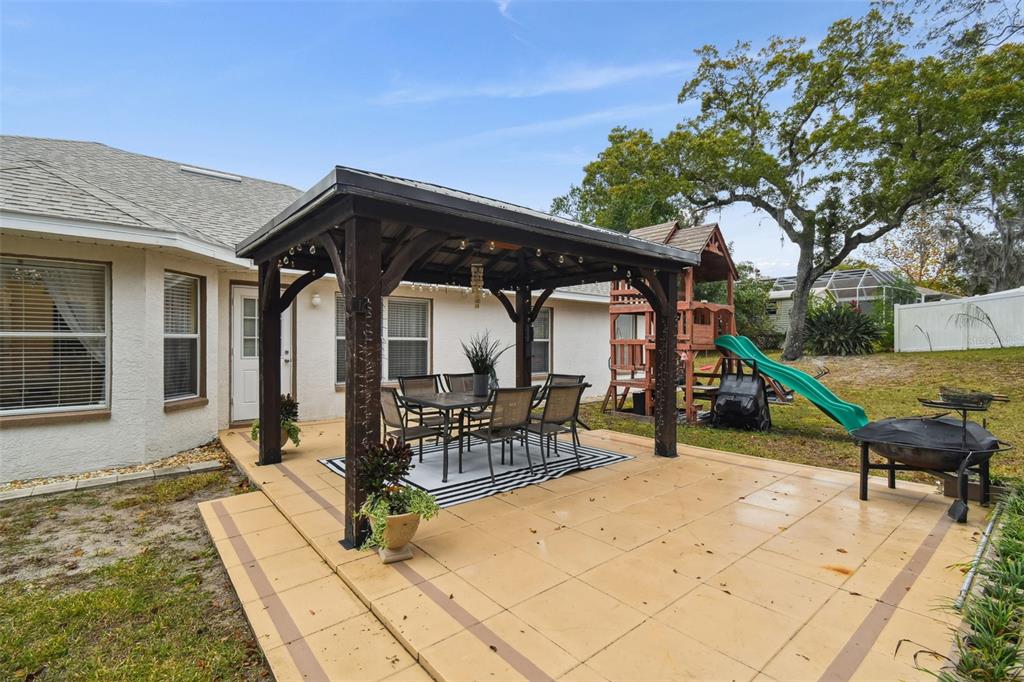 270 Planter Road Spring Hill, FL 34606 - Photo 26 of 33 a view of a house with wooden deck and furniture