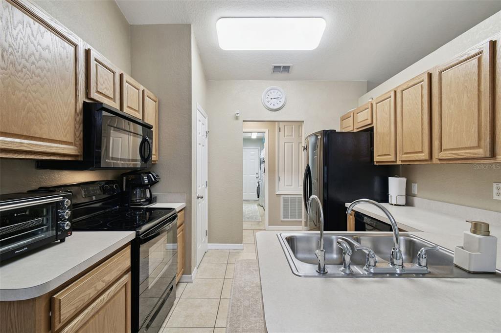 270 Planter Road Spring Hill, FL 34606 - Photo 9 of 33 a kitchen with stainless steel appliances granite countertop a sink refrigerator and microwave