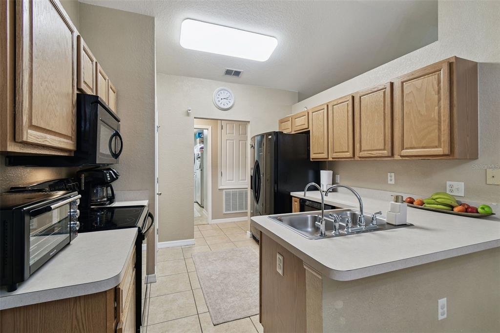 270 Planter Road Spring Hill, FL 34606 - Photo 10 of 33 a kitchen with a sink a refrigerator and cabinets